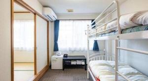 a dorm room with bunk beds and a desk at Business Hotel Fujimi in Fujiyoshida