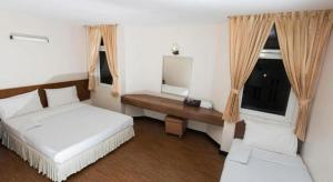 a bedroom with two beds and a desk and a mirror at Muangphol Mansion in Bangkok +73 photos