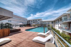 un patio de apartamentos con piscina en un edificio en Zenitude Hôtel-Résidences Le Maestria, en Antibes