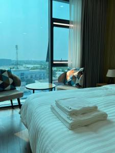 a hotel room with a bed and a large window at Uberzen Residence Hotel in An Dương