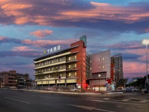 un edificio en una calle de la ciudad con un cielo nublado en 7 Days Inn Foshan Qiandeng Lake, en Nanhai