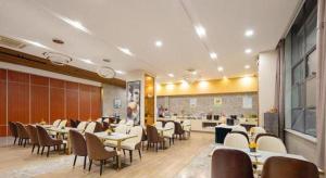 塩城にあるGreenTree Eastern Yancheng Administration Center Hotelのレストラン内のテーブルと椅子のあるダイニングルーム