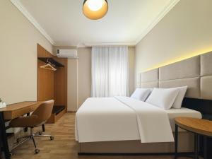 a hotel room with a white bed and a desk at 利恩之家 Maison Lienne in Cairo