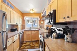 a kitchen with wooden cabinets and a stove top oven at RMR: Sleeping Indian West 1 Condo in Teton Village in Teton Village