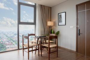 a dining room with a table and chairs and a large window at Mandala Hotel & Suites Hải Dương in Bảo Thap +20 photos