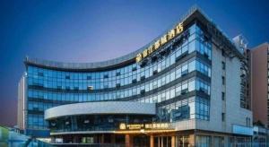 un grand bâtiment avec une enseigne au sommet dans l'établissement Jinjiang Inn Nanjing Changjiang Bridge North Metro Station, à Taishan