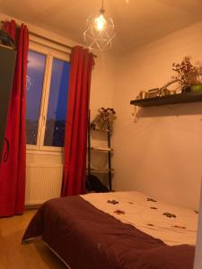 1 dormitorio con 1 cama con cortinas rojas y ventana en Sky Room, en Rouen