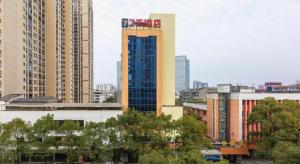 a tall building with a sign on it in a city at 7 Days Inn Pingxiang Railway Station in Pingxiang