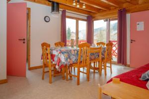 a dining room with a table and chairs and windows at Chalet 331 - Village nordique in La Féclaz