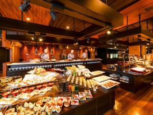 a restaurant with a buffet line with people in the kitchen at Ooedo Onsen Monogatari Premium Kinosaki in Toyooka