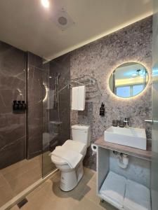a bathroom with a toilet and a sink and a mirror at Fun Stay Inn Hanzhong in Taipei