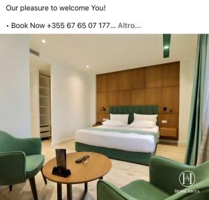 a hotel room with a bed and a table and chairs at Hotel Ascua in Tirana