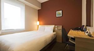 a bedroom with a bed and a desk with a computer at KEIKYU EX INN Keikyu Kawasaki-Station in Kawasaki +136 photos