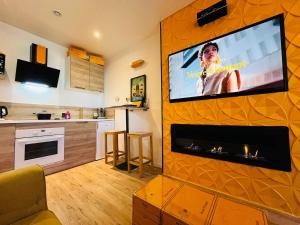 a living room with a flat screen tv on a wall at L'Ecrin de Clicquot, studio cosy au cœur d'Epernay in Épernay +20 photos