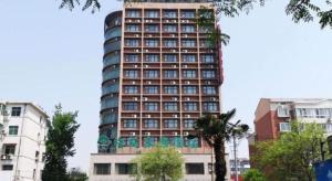 un grand bâtiment avec beaucoup de fenêtres dans l'établissement GreenTree Inn Luoyang West Zhongzhou Road Business Hotel, à Luoyang