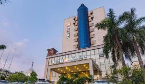 a hotel with a blue building with a palm tree at Jinjiang Inn Select Foshan Nanhai Guicheng Metro Station in Nanhai