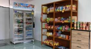 a store with a refrigerator and shelves filled with food at NK garden Hotel @Suratthani Airport in Ban Don Rak