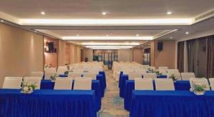 une salle de banquet avec des tables bleues et des chaises blanches dans l'établissement IU Hotel Guiyang Convention and Exhibition Center Financial City, à Jinzhuzhen