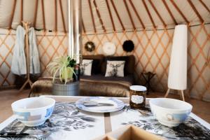 a table in a yurt with two bowls on it at Altitude Ecolodge Yourte in Ilonse