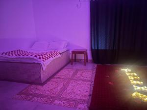 a purple room with a bed and a chair at O Retorno do Prazer 