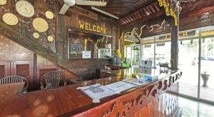 un bar dans un restaurant avec une horloge sur le mur dans l'établissement Super OYO Capital O 90659 Raintown Timbers Hotel, à Taiping