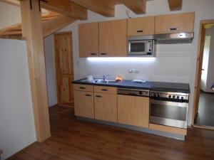 a kitchen with wooden cabinets and a stove top oven at Apartment U Lochů in Kňovičky