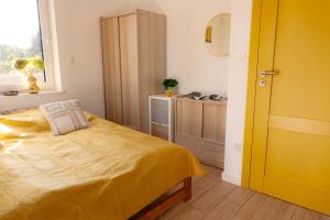 a bedroom with a yellow bed and a window at Radawnica pl - Tu odpoczniesz! in Skorka