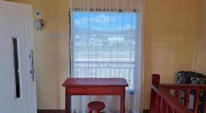 une pièce avec une fenêtre et une table en bois dans l'établissement Hotel O Puri Azzura Danau Ranau Near Danau Ranau Pusri, à Jepara 32 autres photos