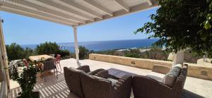 a patio with wicker chairs and a view of the ocean at Villa Bianca in Ferma