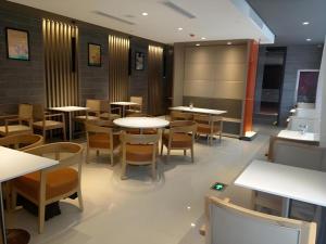 HuangdaoにあるJinjiang Inn Select Qingdao West Coast Coach Exhibition Center High-Speed Railway Stationの部屋にテーブルと椅子があるレストラン