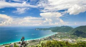 Da'ancunにあるGreenTree Alliance Sanya Jiyang District Yalongwan Road Hotelの海を見渡す丘の上に自転車に乗る者