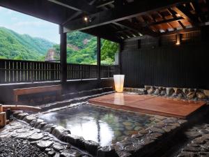 a pool of water in a room with a view at Yubaraonsen Yubaranoyado Komeya in Maniwa