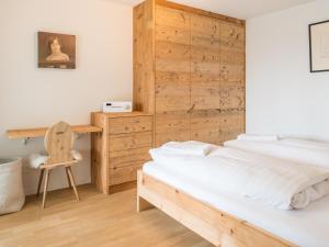 - une chambre avec un lit et un mur en bois dans l'établissement Edelweiss Mira Neiv, à Flims