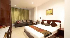 a bedroom with a large bed and a couch at Phanthipha Residence in Ban Si Than