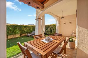 a wooden table and chairs on a patio at Casa Lisa Agorà mare e relax in Villasimius