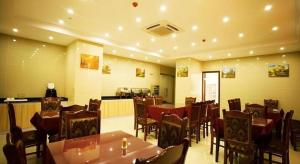 une salle à manger avec des tables et des chaises dans un restaurant dans l'établissement GreenTree Inn Jianyan Renmin Middle Eastern Sleepless city Pedestrian Express Hotel, à Magou