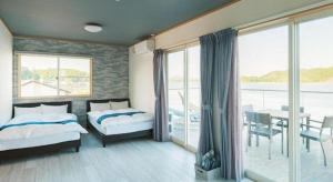 une chambre avec deux lits et un balcon dans l'établissement THE TRAILERHOUSE VILLAGE AMAKUSA MARINA, à Nobotate