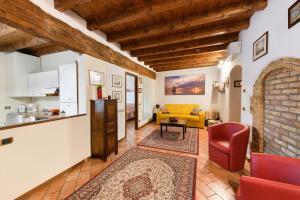 un salon avec un canapé jaune et une cuisine dans l'établissement Casa Laura, à Salò