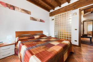 - une chambre avec un lit et un mur carrelé dans l'établissement Casa Laura, à Salò