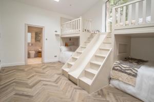 a white staircase in a room with a bedroom at Luxury cottage with high-end bathrooms - NEWLY REFURBISHED in Sutton Scotney