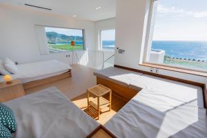 une chambre avec deux lits et une grande fenêtre dans l'établissement Oceanview,Villa de 427, à Seogwipo 97 autres photos