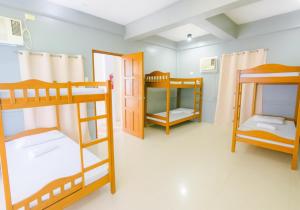 a room with three bunk beds in it at Hola Hostel Puerto Princesa in Puerto Princesa City +31 photos