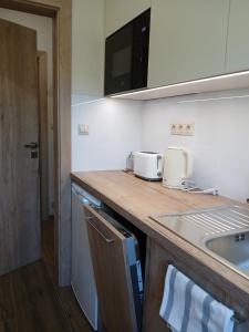 a kitchen with a counter top and a sink at Apartmány ALTI in Prosiek +20 photos