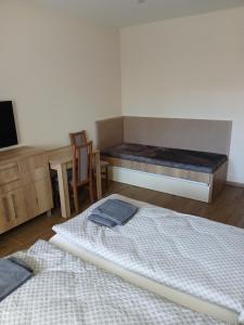 a room with two beds and a bench in it at Apartmány ALTI in Prosiek