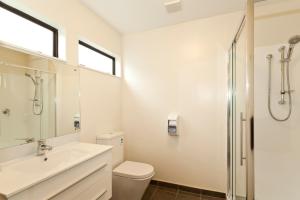 La salle de bains est pourvue de toilettes, d'un lavabo et d'une douche. dans l'établissement Gothic Heights Motel, à Christchurch
