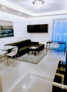 a living room with a black couch and a table at NiceToSeeYou Warsaw Apartament Centrum-Metro-Deluxe-self check-in in Warsaw