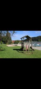 a park with a playground with two swings at Un coin de paradis au pied des pistes avec balcon in Métabief