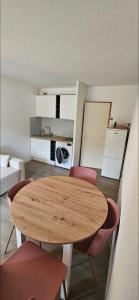 a room with a table and chairs and a kitchen at Un coin de paradis au pied des pistes avec balcon in Métabief