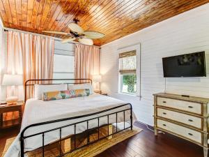a bedroom with a bed and a ceiling fan at Blue Cat in Tybee Island +41 photos