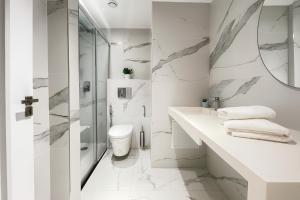 a white bathroom with a shower and a toilet at Luxueux immeuble en plein boulevard Sidi Yahia in Hydra